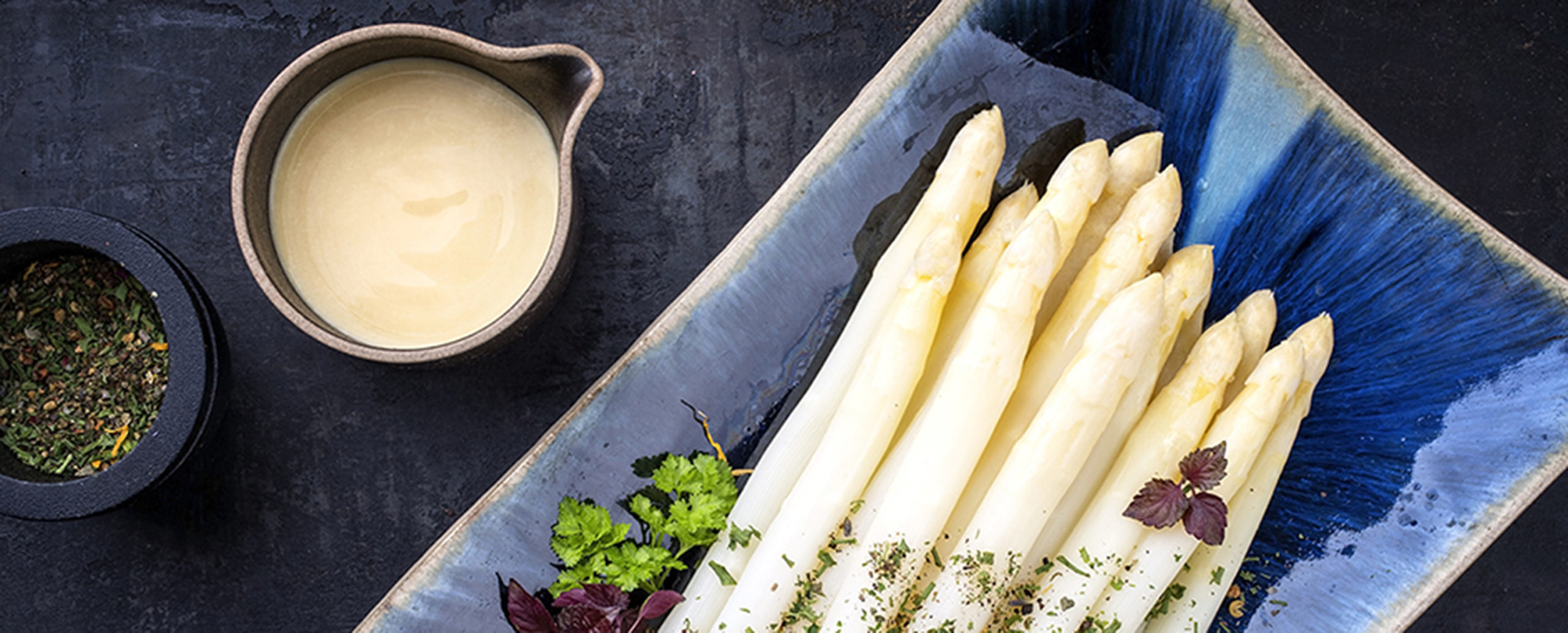 Traditional boiled white asparagus with sauce hollandaise and wi